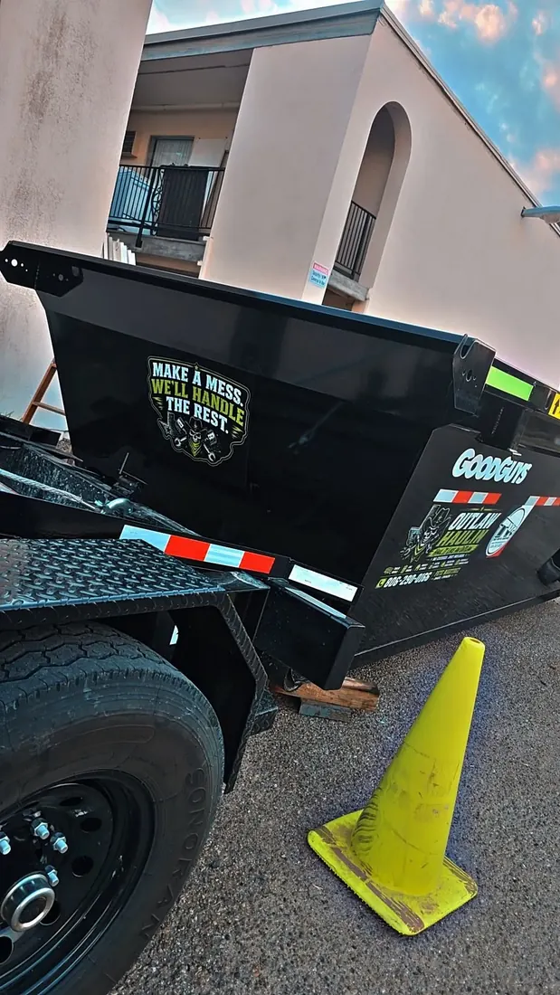 An Outlaw Haulin dump trailer staged at an apartment complex in Amarillo for a unit cleanout